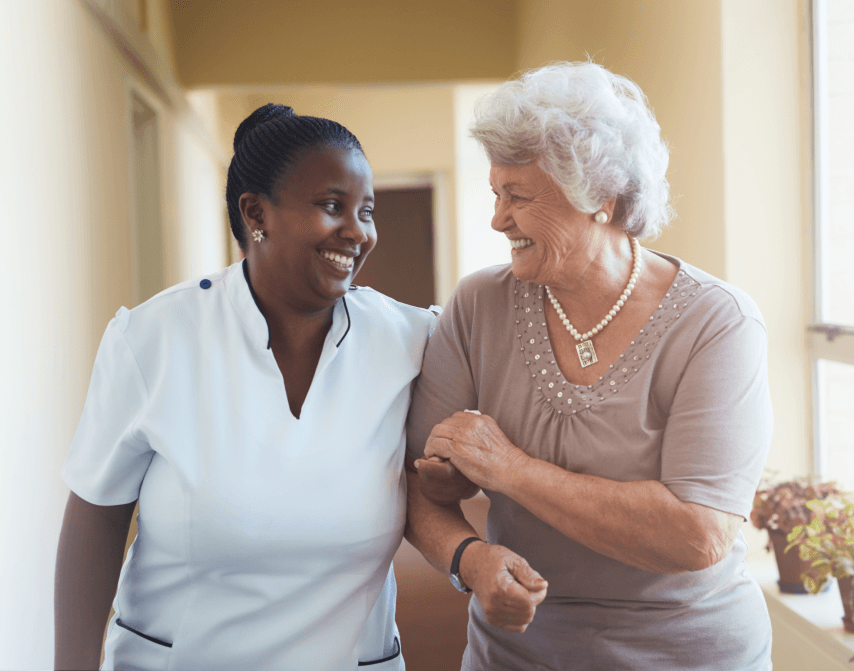 Multilingual S&A caregiver assisting an elderly client at home in New York — compassionate home health aide and personal care services across the five boroughs, Long Island, and Westchester.